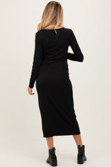 woman wearing a black long sleeve maternity dress, showing a fitted silhouette from the back