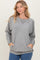 woman wearing a gray long sleeve sweatshirt with a relaxed fit and front pockets, styled with a round neckline