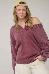woman wearing a maroon off-the-shoulder sweater with ribbed details and a relaxed fit