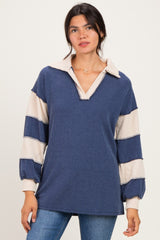 woman wearing a navy blue and cream striped pullover with a collar and puffed sleeves