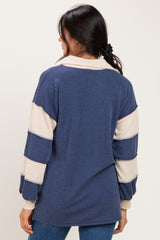 woman wearing a navy blue and cream striped oversized sweater with a collar and back seam detail