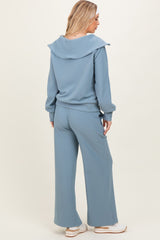 woman wearing a light blue ribbed matching lounge set with a shawl collar and wide-leg pants