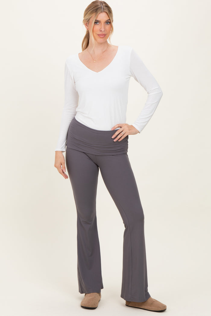 woman wearing a white long sleeve v-neck top and gray flared yoga pants