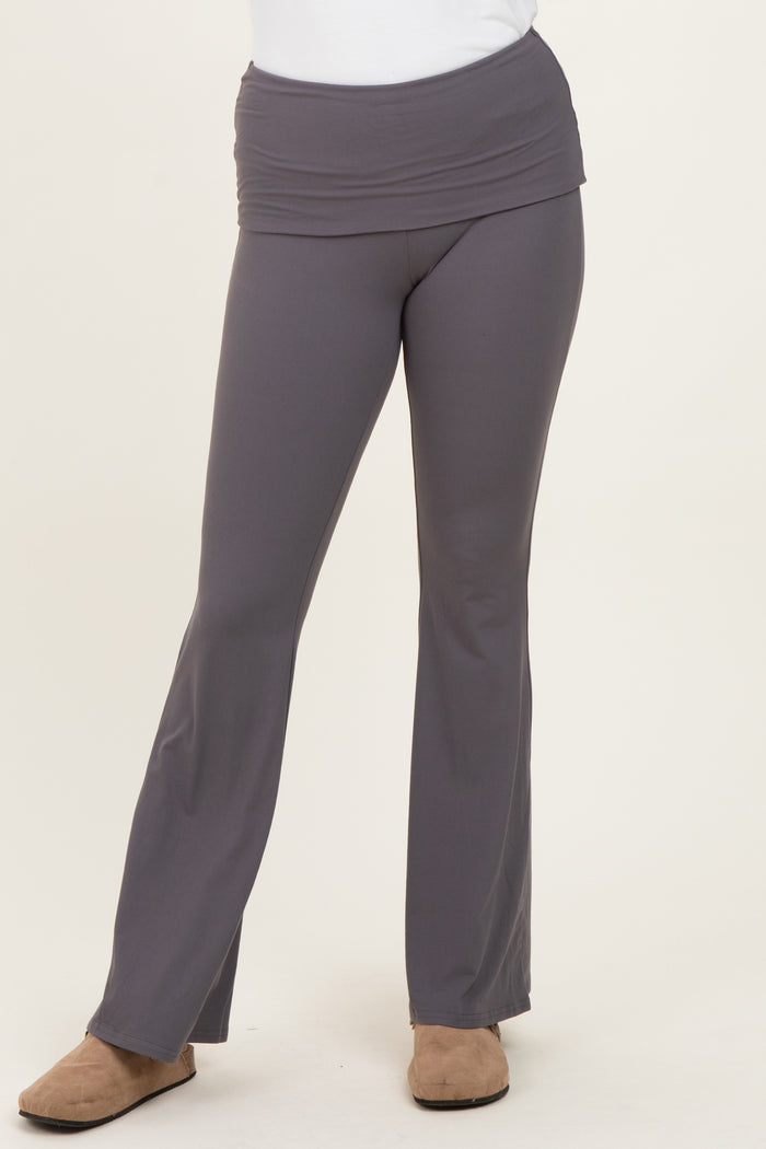 woman wearing gray fold-over waistband flared pants with a fitted style and paired with casual footwear