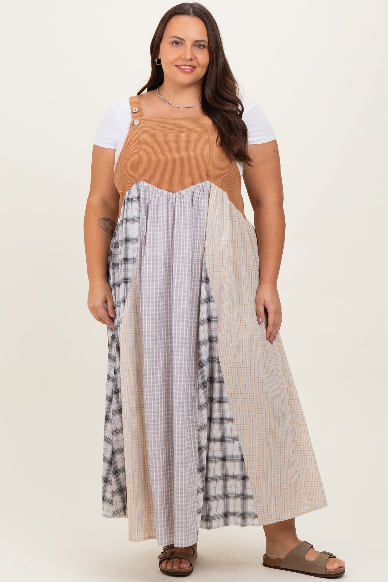 woman wearing a plus size color block maxi dress with a tan corduroy top and plaid skirt, paired with brown sandals