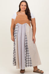 woman wearing a plus size color block maxi dress with a tan corduroy top and plaid skirt, paired with brown sandals