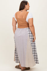woman wearing a tan ribbed crop top paired with a long plaid maxi skirt in mixed fabrics from the back
