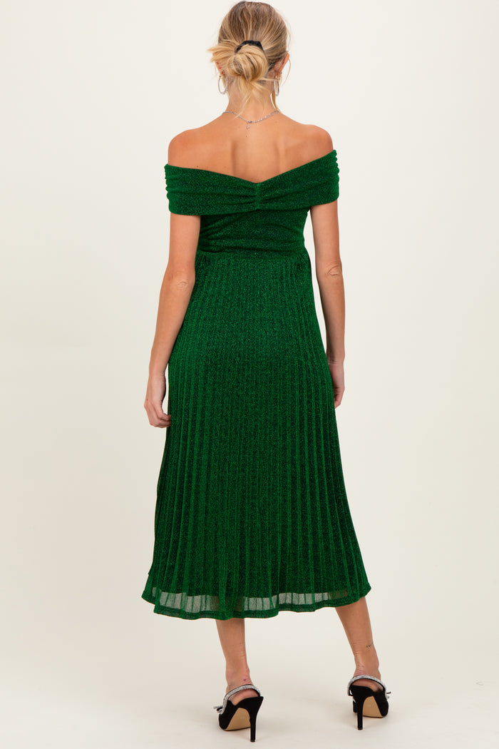 woman wearing an off-shoulder green maternity dress with a pleated design, showing a baby bump from the back