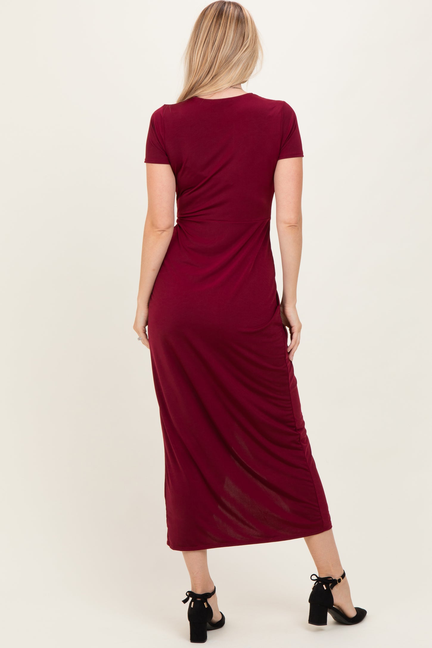 woman wearing a burgundy short sleeve maxi dress with gathered detailing at the back