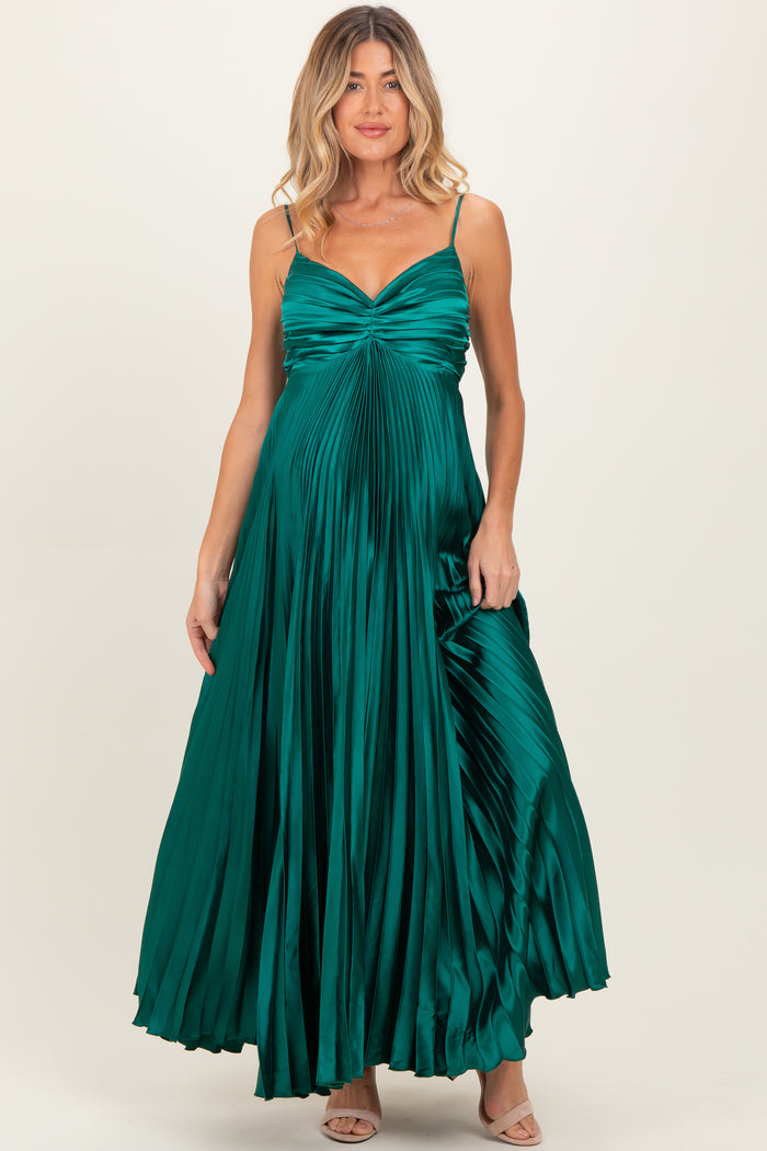 woman wearing a teal maternity wear dress with pleated design and spaghetti straps, showing her baby bump
