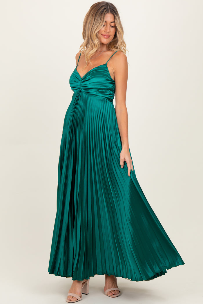 woman wearing a green pleated maternity gown with a sweetheart neckline and spaghetti straps, highlighting her baby bump