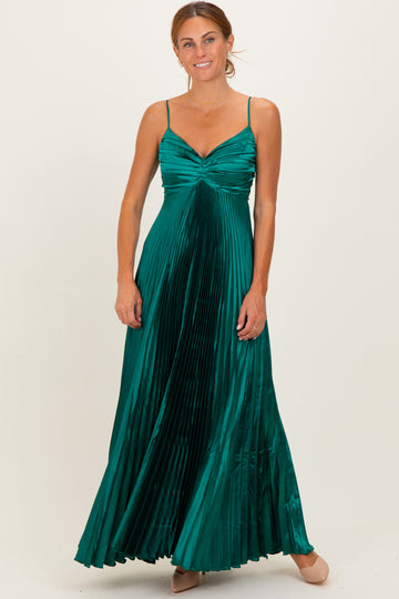woman wearing a pleated emerald green maxi dress with a sweetheart neckline and adjustable spaghetti straps