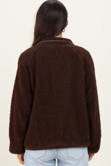 woman wearing a brown fleece jacket with a relaxed fit and collared neckline, view from the back