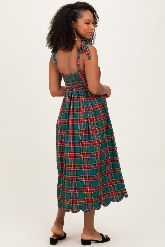 woman wearing a green plaid midi dress with a smocked back and halter straps, shown from the back