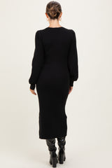 woman wearing a black ribbed maternity dress with long sleeves and a fitted silhouette, viewed from the back