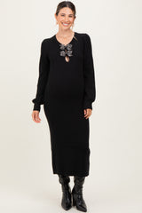 woman wearing a black ribbed maternity dress with a decorative bow detail and long sleeves, showcasing her baby bump
