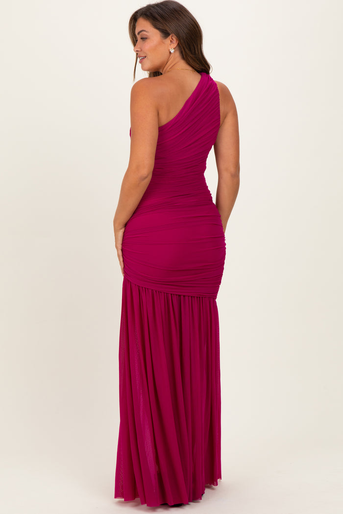 woman wearing a fuchsia one-shoulder maternity gown with ruched detailing and a flowing skirt