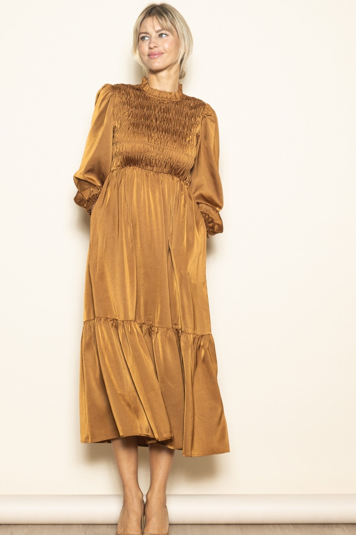 woman wearing a mustard yellow long sleeve smocked maxi dress with a tiered skirt and a relaxed fit