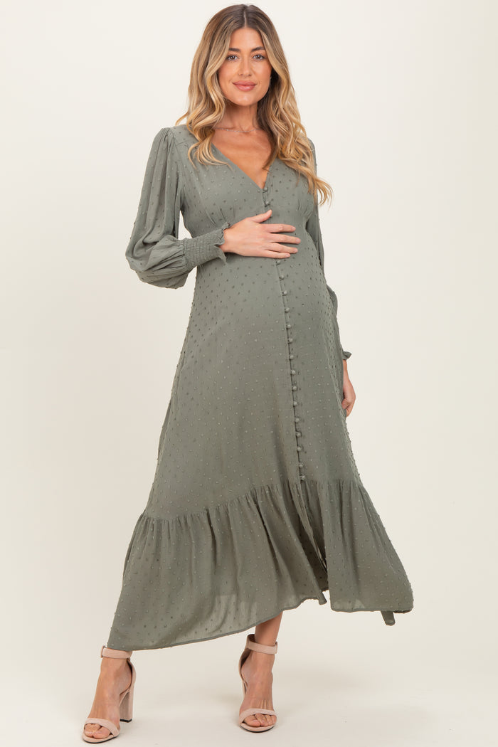 woman wearing a dusty green maternity dress with long sleeves and a tiered hem, highlighting her baby bump