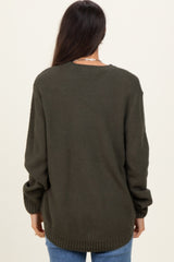 woman wearing an oversized olive green textured sweater with long sleeves and a relaxed fit