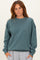 woman wearing a teal oversized sweatshirt with long sleeves and a relaxed fit