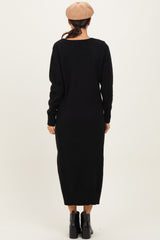 woman wearing a black long sleeve sweater dress, viewed from the back, paired with a beige beret and black ankle boots