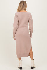 woman wearing a light pink long sleeve maternity sweater dress with side slits and a relaxed fit