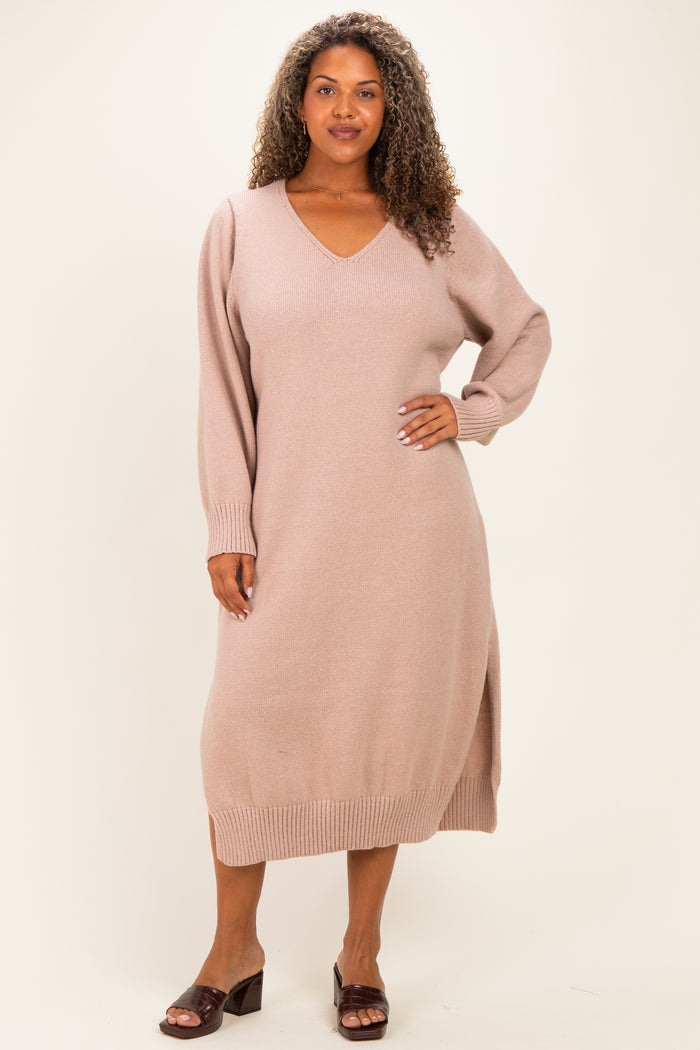 woman wearing a light pink long sleeve plus-size sweater dress with a v-neck and side slits