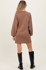woman wearing a brown long sleeve maternity dress with a relaxed fit and balloon sleeves, viewed from the back