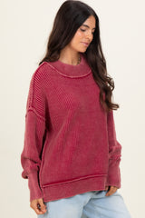 woman wearing a maroon ribbed oversized sweater with a relaxed fit and long sleeves