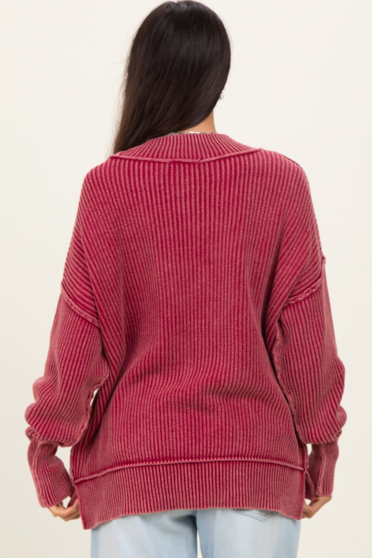 woman wearing a ribbed oversized maroon sweater with a relaxed fit and dropped shoulder seams