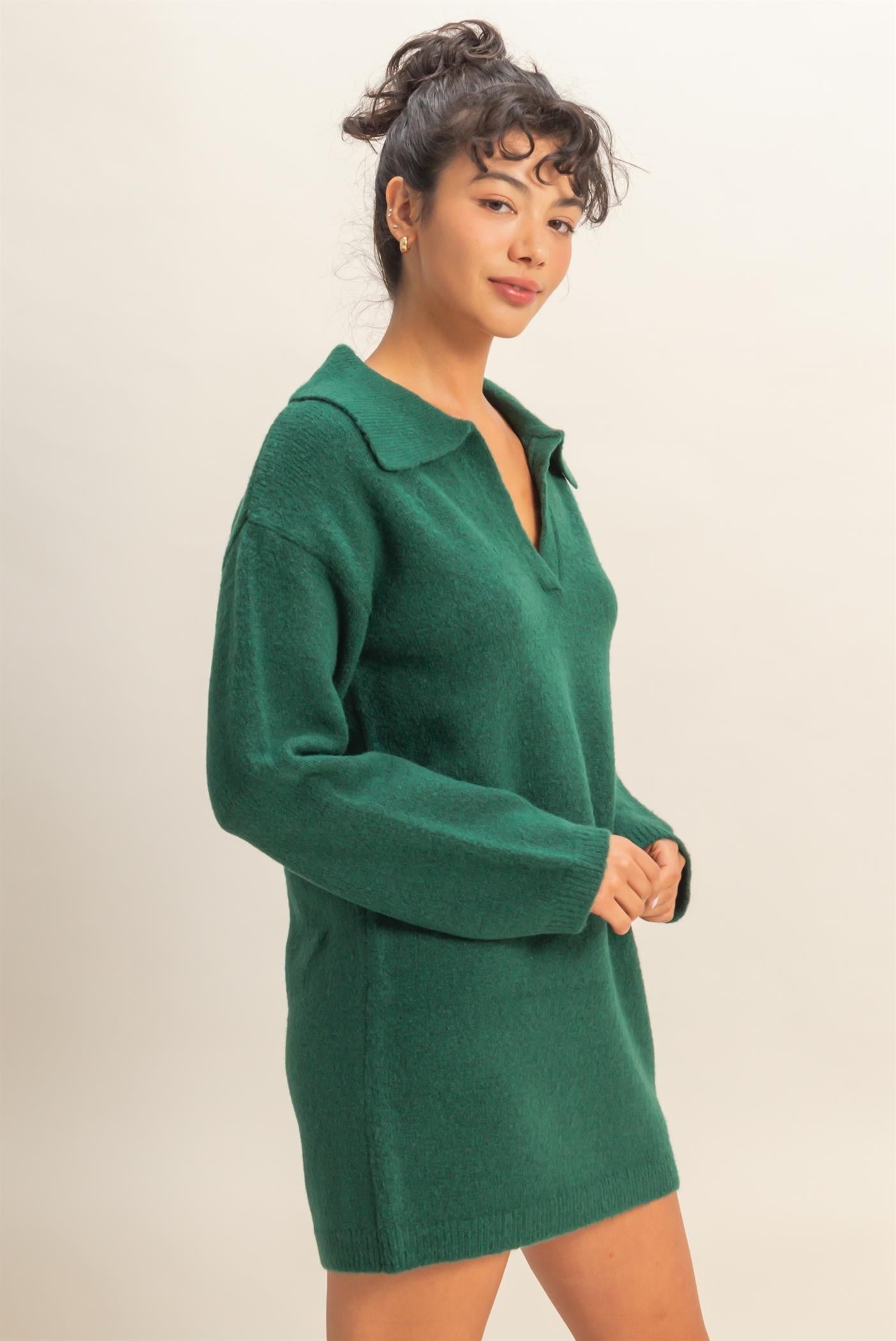 woman wearing a green oversized sweater dress with a collar and long sleeves