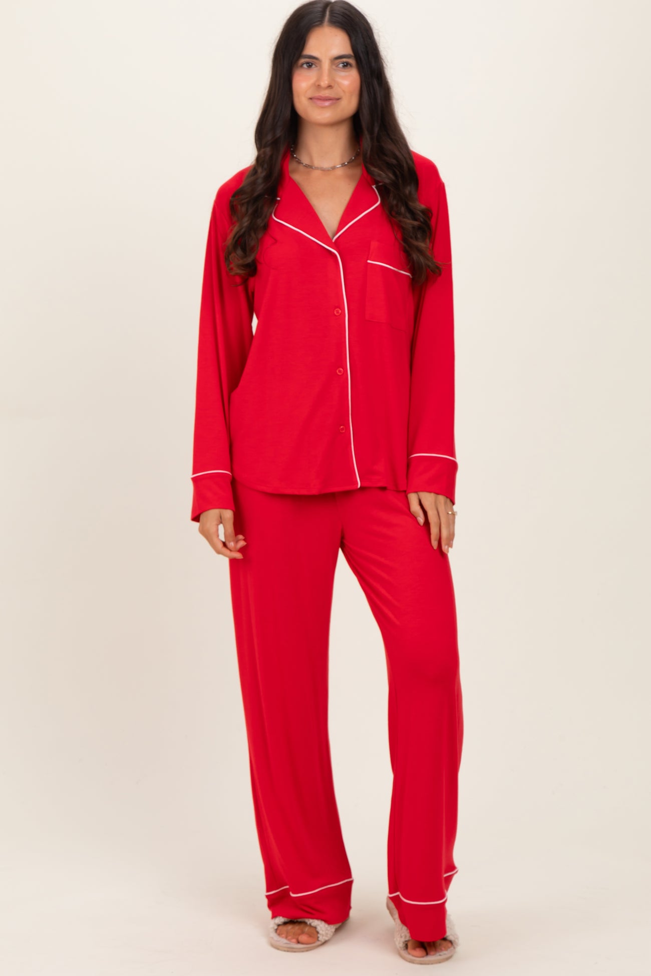 woman wearing a red long sleeve pajama set with white piping details