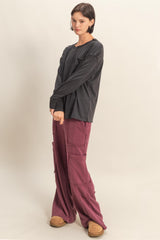 woman wearing a black long sleeve shirt and burgundy wide-leg cargo pants