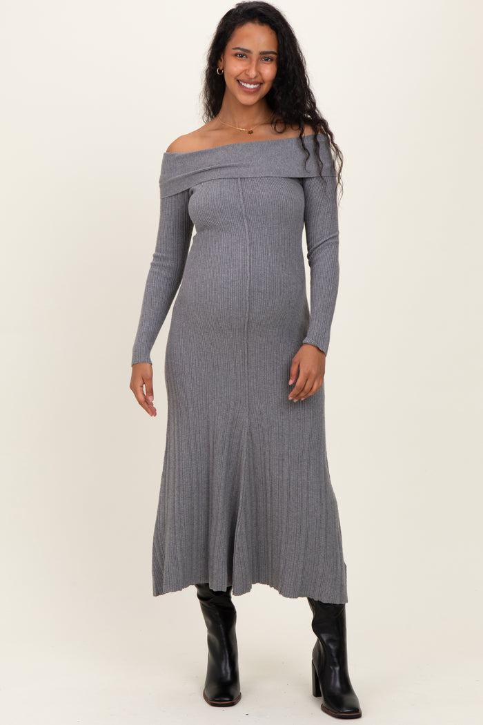 woman wearing a gray off-shoulder maternity dress with a fitted silhouette and long sleeves, showcasing her baby bump