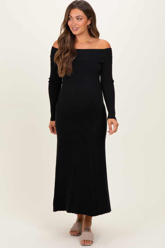 woman wearing a black off-the-shoulder ribbed maternity dress, showing her baby bump