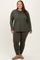 woman in a plus size olive green long sleeve top and matching leggings, standing against a neutral background