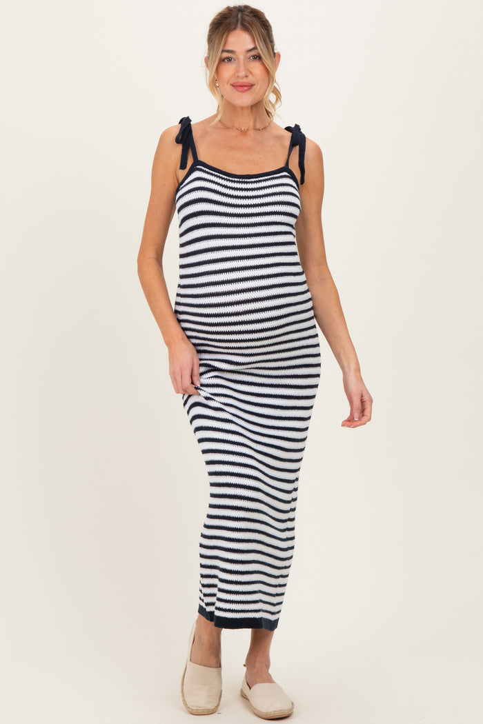 woman wearing a navy and white striped maternity maxi dress with tie shoulder straps and a fitted silhouette