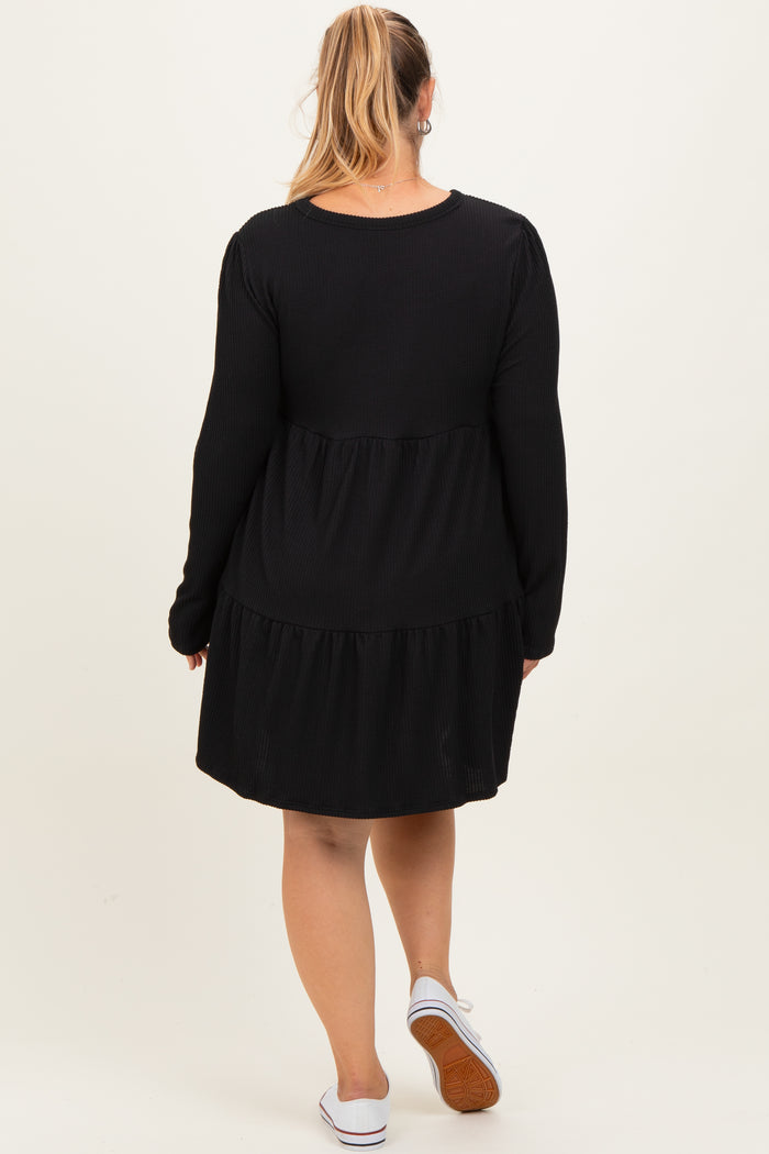 woman wearing a black long sleeve maternity dress with a tiered skirt and a relaxed fit, showing her back