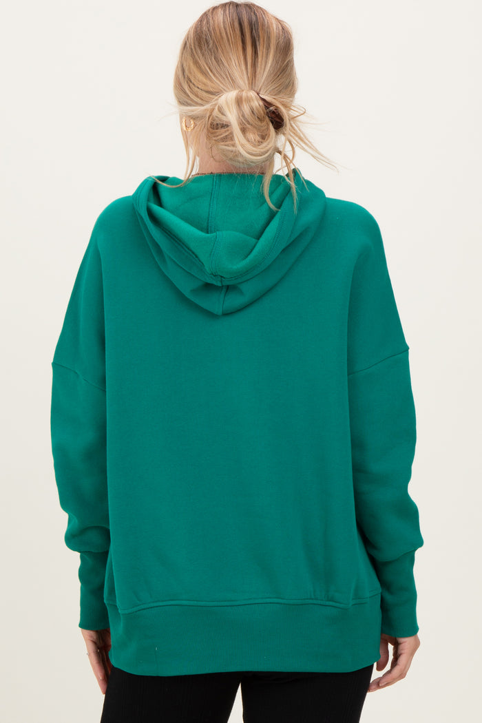 woman wearing a green oversized hoodie with a hood and relaxed fit from the back