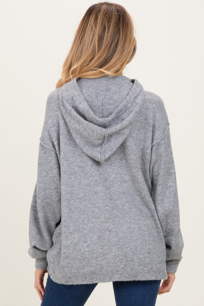 woman wearing a cozy grey maternity hoodie with a relaxed fit and a hood, showing the back view
