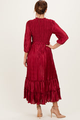 woman wearing a burgundy pleated midi dress with a smocked bodice and ruffle hem, seen from the back