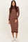 woman wearing a brown and beige striped ribbed midi dress with long sleeves and a high neckline, paired with white sneakers
