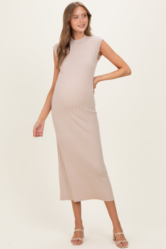 woman wearing a light beige ribbed maternity dress accentuating her baby bump