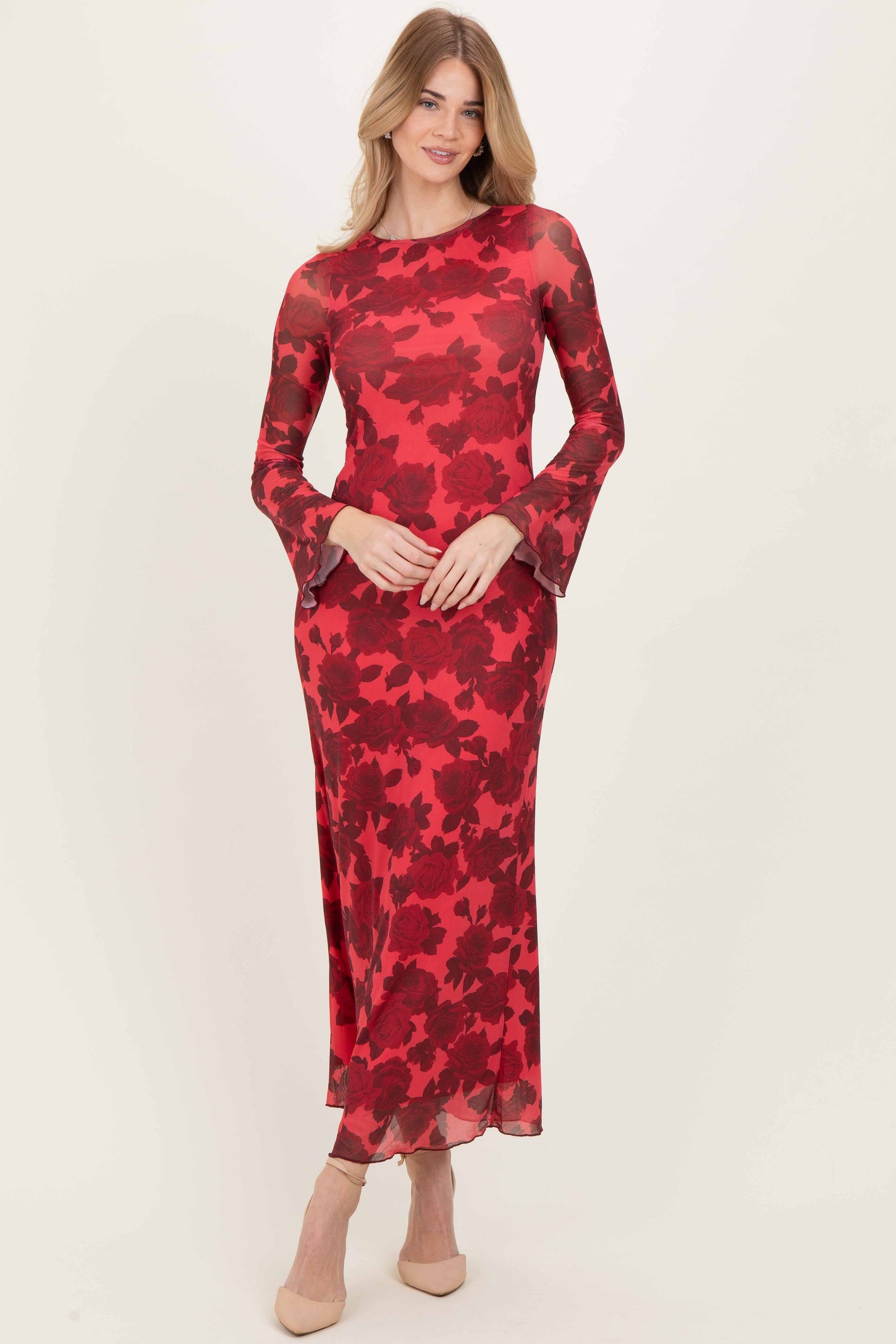 woman wearing a red floral long sleeve dress with bell sleeves and a fitted silhouette