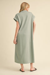woman wearing a loose-fitting sage green maxi dress with rolled sleeves and a relaxed silhouette from the back