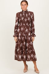 woman wearing a brown floral print long sleeve midi dress with smocked bodice and tiered skirt