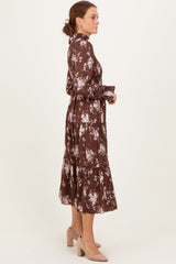 woman wearing a brown floral tiered midi dress with long sleeves and a side profile view