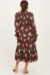 woman wearing a brown floral tiered midi dress with long sleeves and smocked details, seen from the back