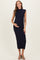 woman wearing a navy ribbed maternity dress, showcasing her baby bump, with a high neckline and cap sleeves
